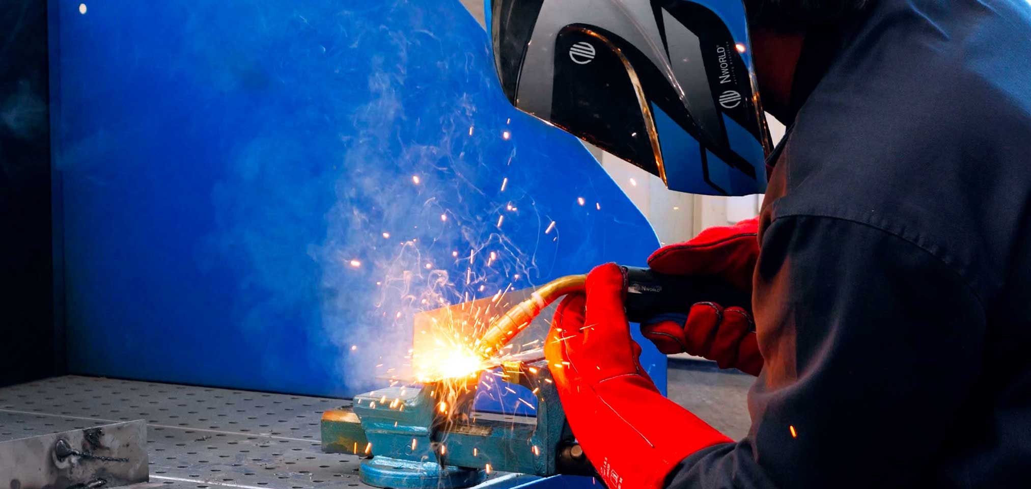 saldatore con casco e torcia nworld a lavoro